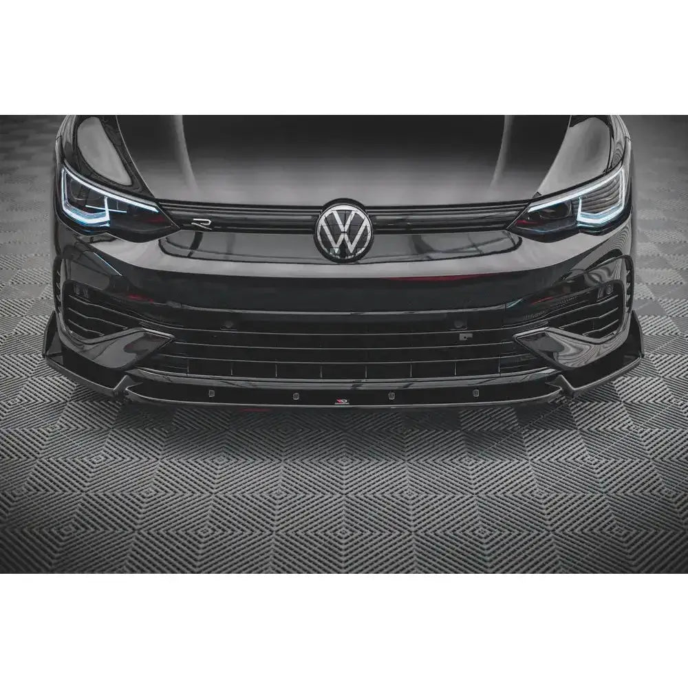 Frontsplitter til Volkswagen Golf R Mk8 V.2 vist foran på svart bil med LED-lykter og blank spoiler.