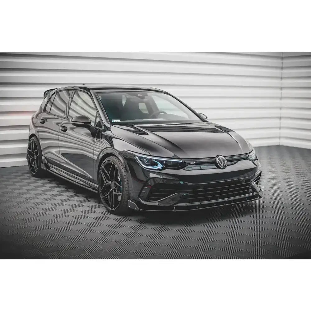 Front lip på Volkswagen Golf R Mk8 med blank finish og lav frontspoiler sett skrått forfra innendørs.