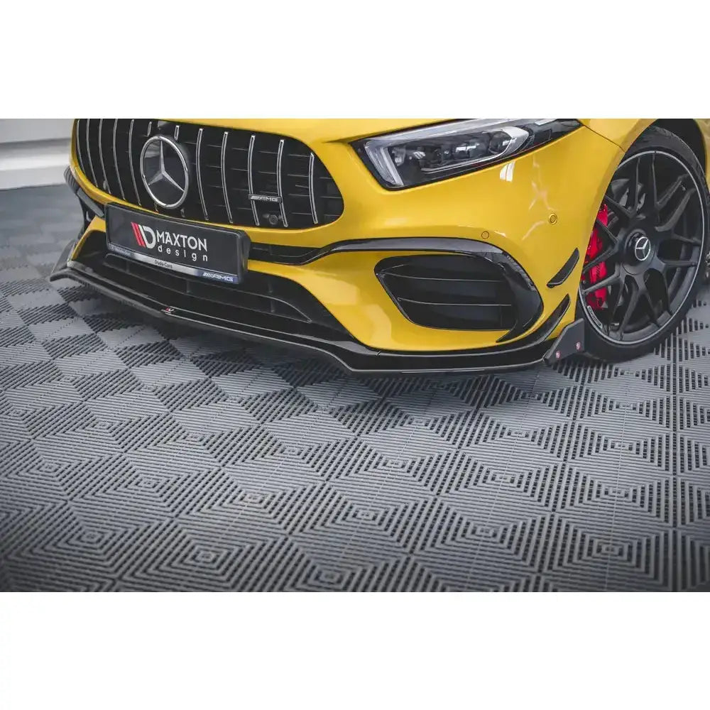 Frontsplitter på gul Mercedes-AMG A45 S med svarte felger og røde bremsekalipere, nærbilde fra venstre.