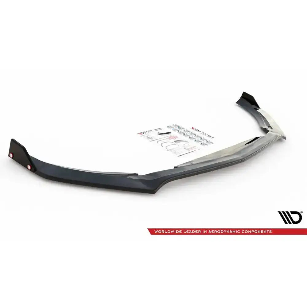 Front lip til Mercedes-AMG A45 S V.3 med svart plastspoiler, monteringsutstyr og manual på hvit bakgrunn.