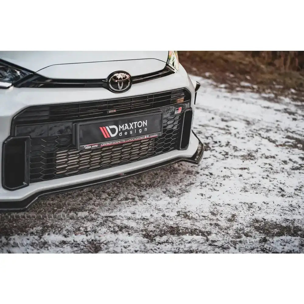 Frontsplitter til Toyota GR Yaris Mk4 med sort grill og Maxton Design-skilt, sett fra lav vinkel.