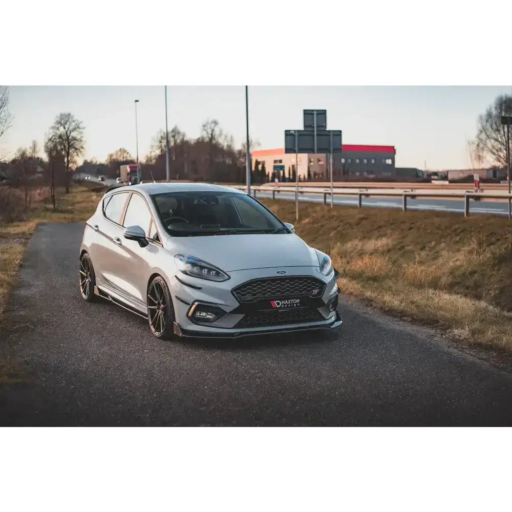 Frontspoiler på hvit Ford Fiesta ST med svarte felger og senket understell parkert på asfalt.