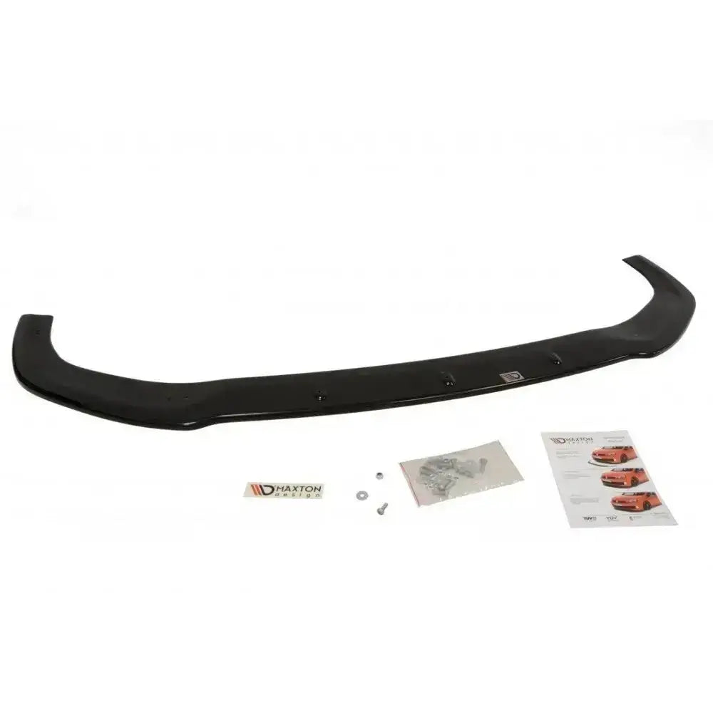 Front lip til Ford Fiesta Mk7 2013-2016 i sort plast, sett ovenfra med monteringsdeler og instruksjoner.
