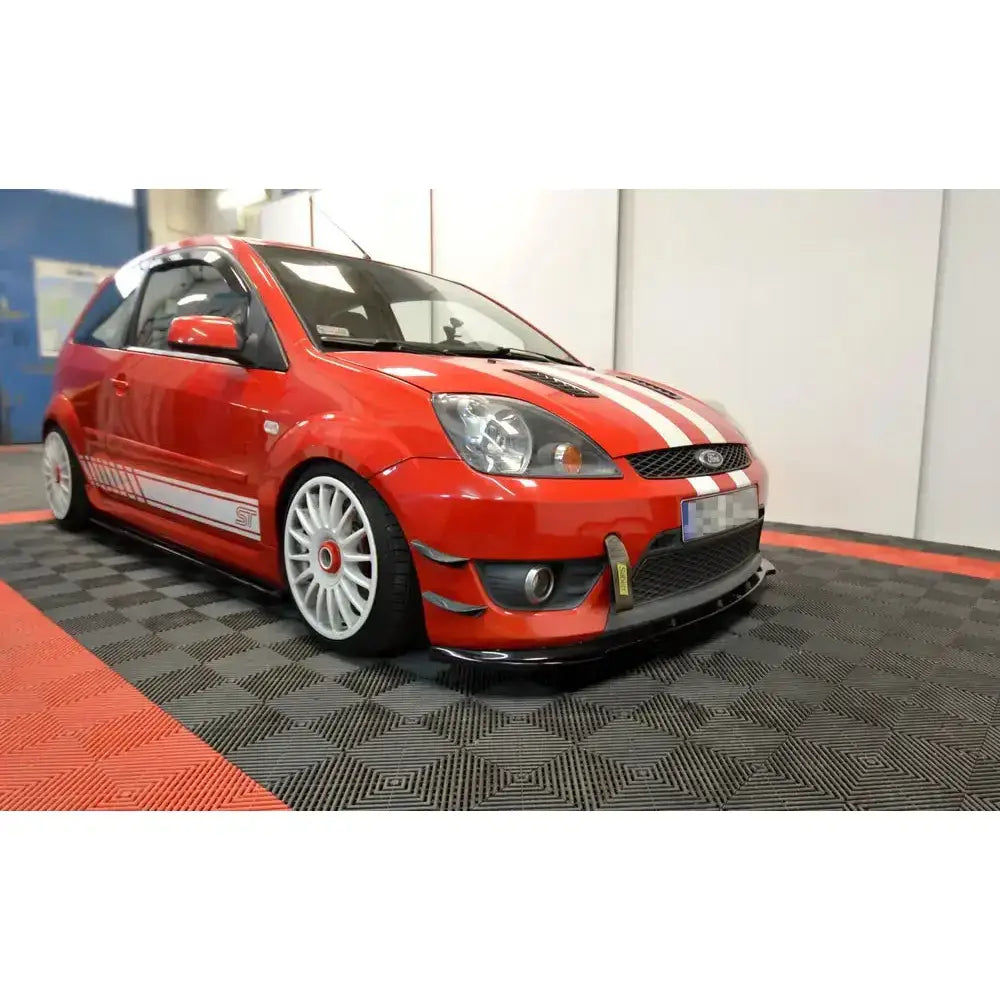 Frontspoiler Ford Fiesta VI ST på rød sportsbil med hvite felger, striper og modifisert frontfanger.