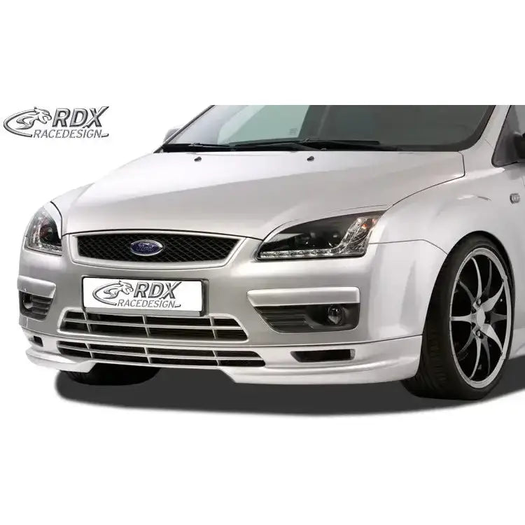 Front lip Ford Focus II 04-12 montert på sølvfarget bil, sorte felger og detaljerte grill- og tåkelys.