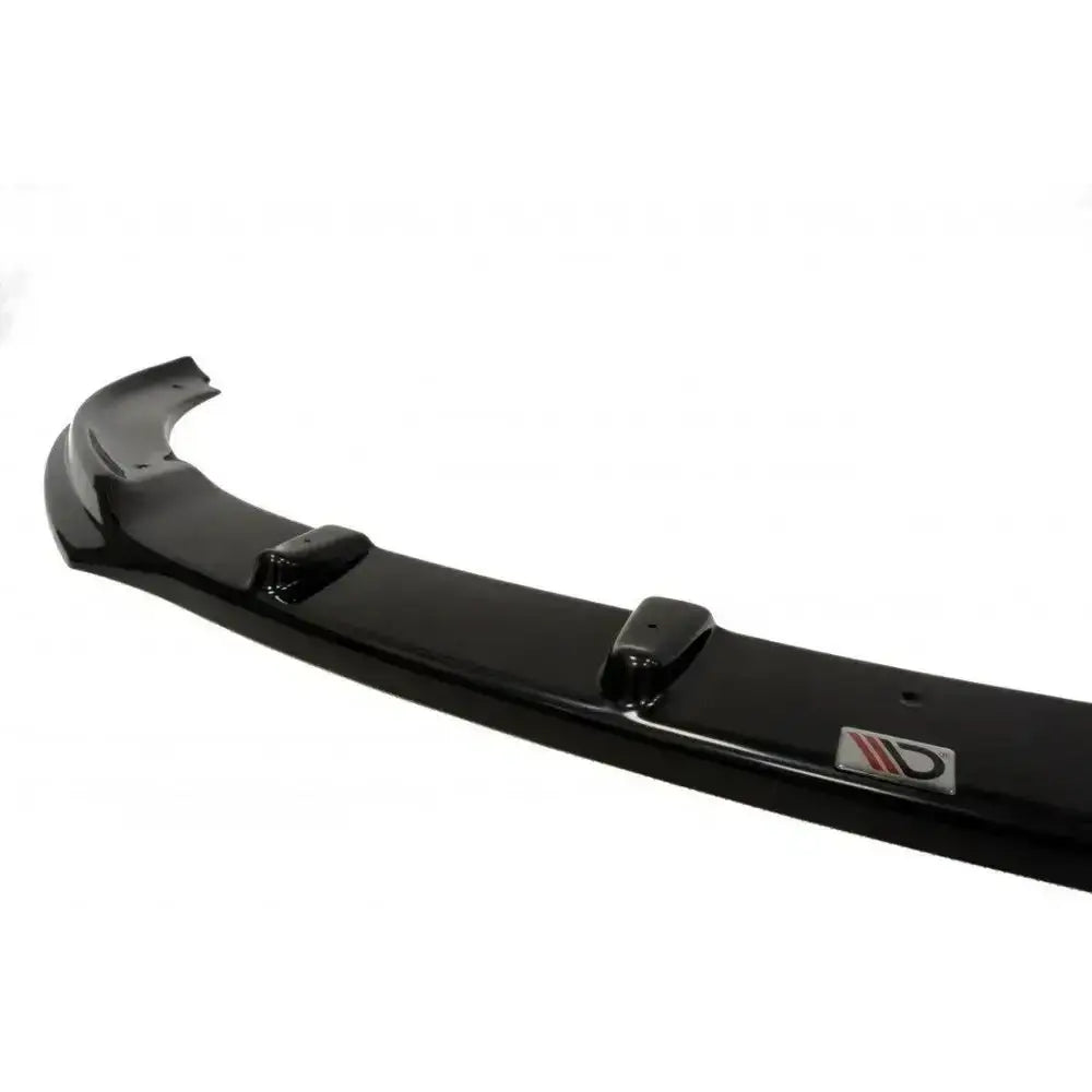 Front lip Ford Focus II Facelift i sort glanset plast med metalllogo og markerte forhøyninger.
