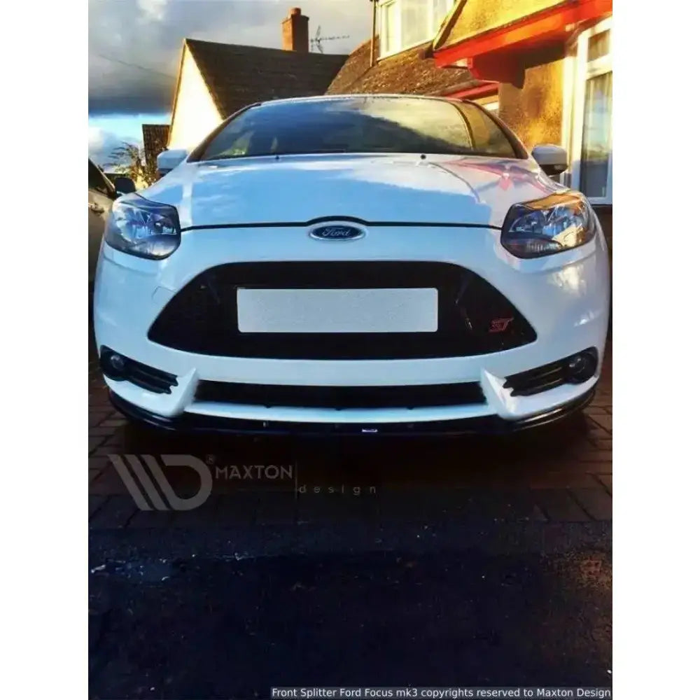 Front splitter på hvit Ford Focus Mk3 St Preface, sett rett forfra med svart grill på innkjørsel.
