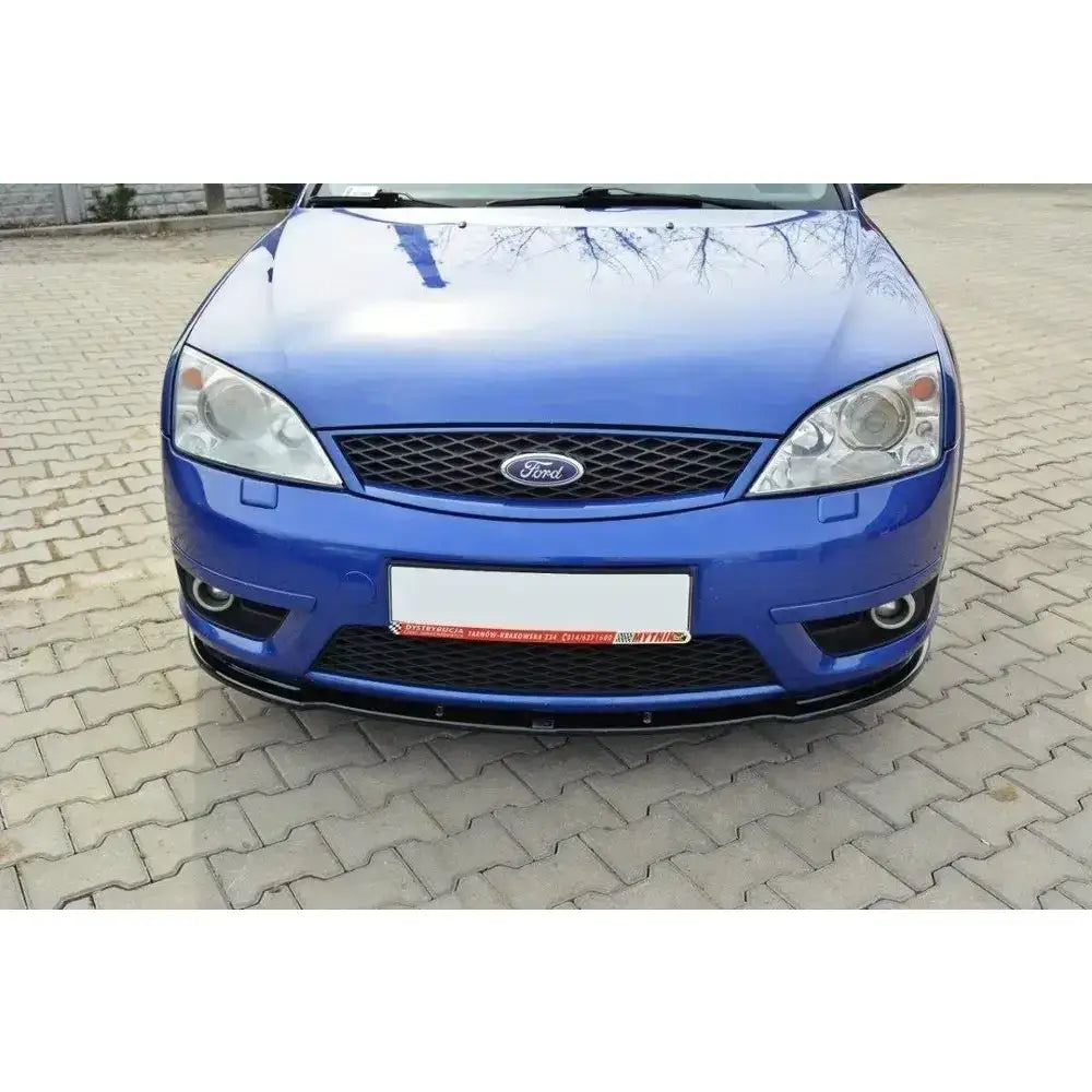Frontspoiler Ford Mondeo Mk3 St220 vist på blå bil forfra med grill og hovedlys på brostein.