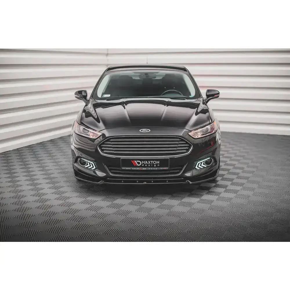 Frontspoiler på Ford Mondeo Mk5 14-19 sett forfra med kromgrill og LED-lys, innendørs på rutegulv.