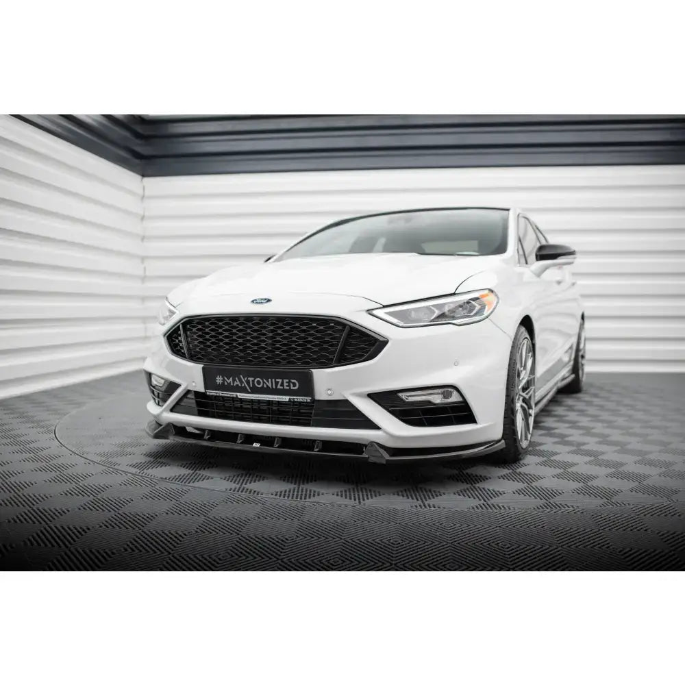 Frontspoiler til Ford Mondeo Sport Mk5 Facelift montert på hvit bil sett forfra i lyst rom.