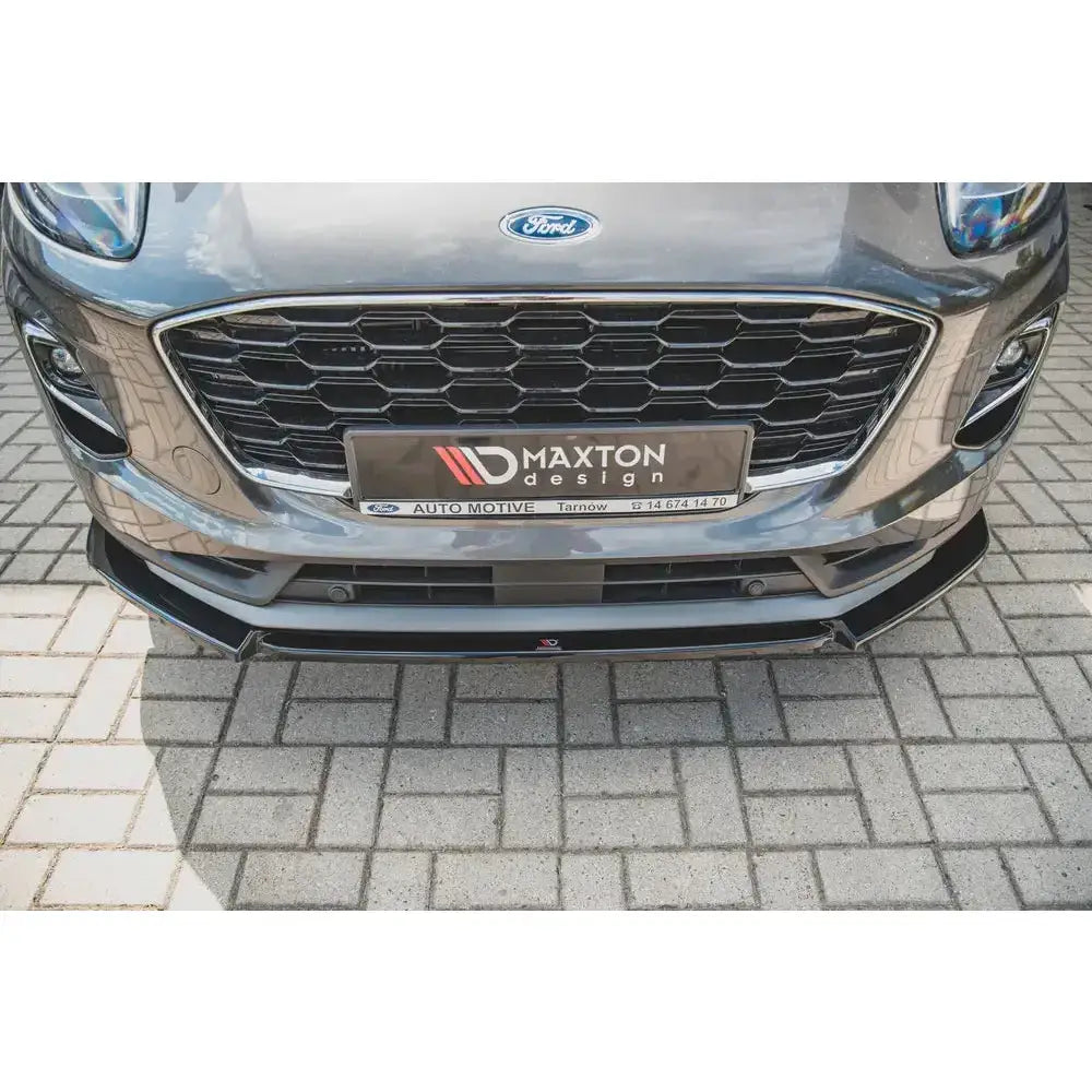 Frontspoiler til Ford Puma, sort plast med bikubemønstret grill og markerte kanter, sett forfra.