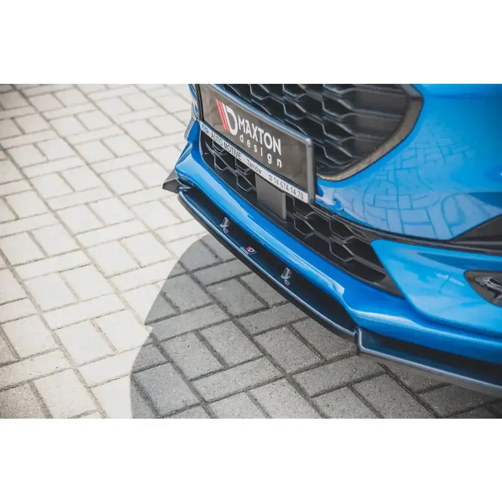 Front splitter på Ford Puma St-Line, sort plast foran grill med bikakemønster, parkert på belegningsstein.