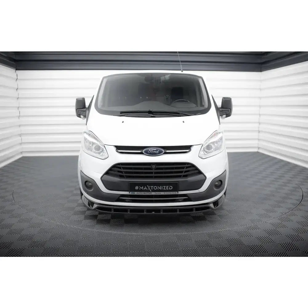 Frontsplitter på Ford Transit Custom Mk1 hvit varebil sett forfra med sorte detaljer i lyst rom.