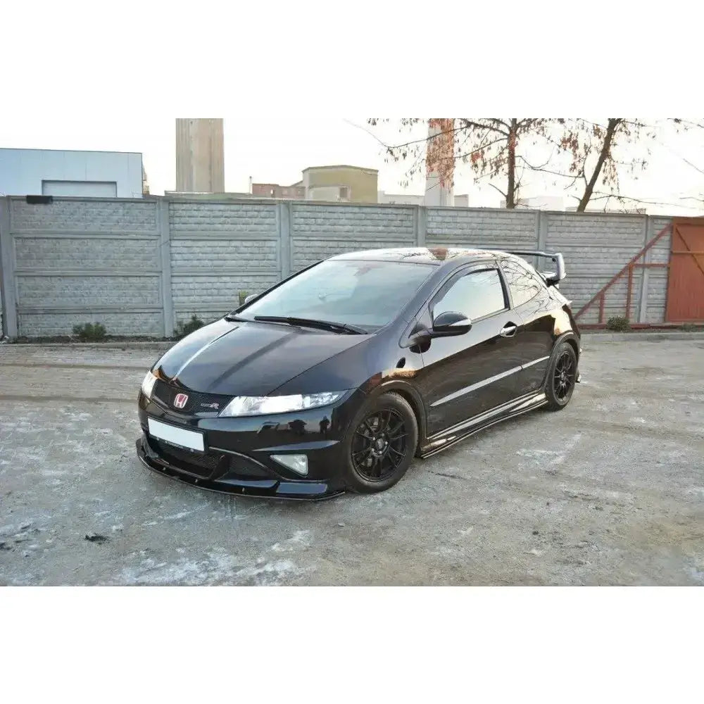 Front splitter Honda Civic VIII Type R med lav frontspoiler og mørke felger, parkert foran grå murvegg.