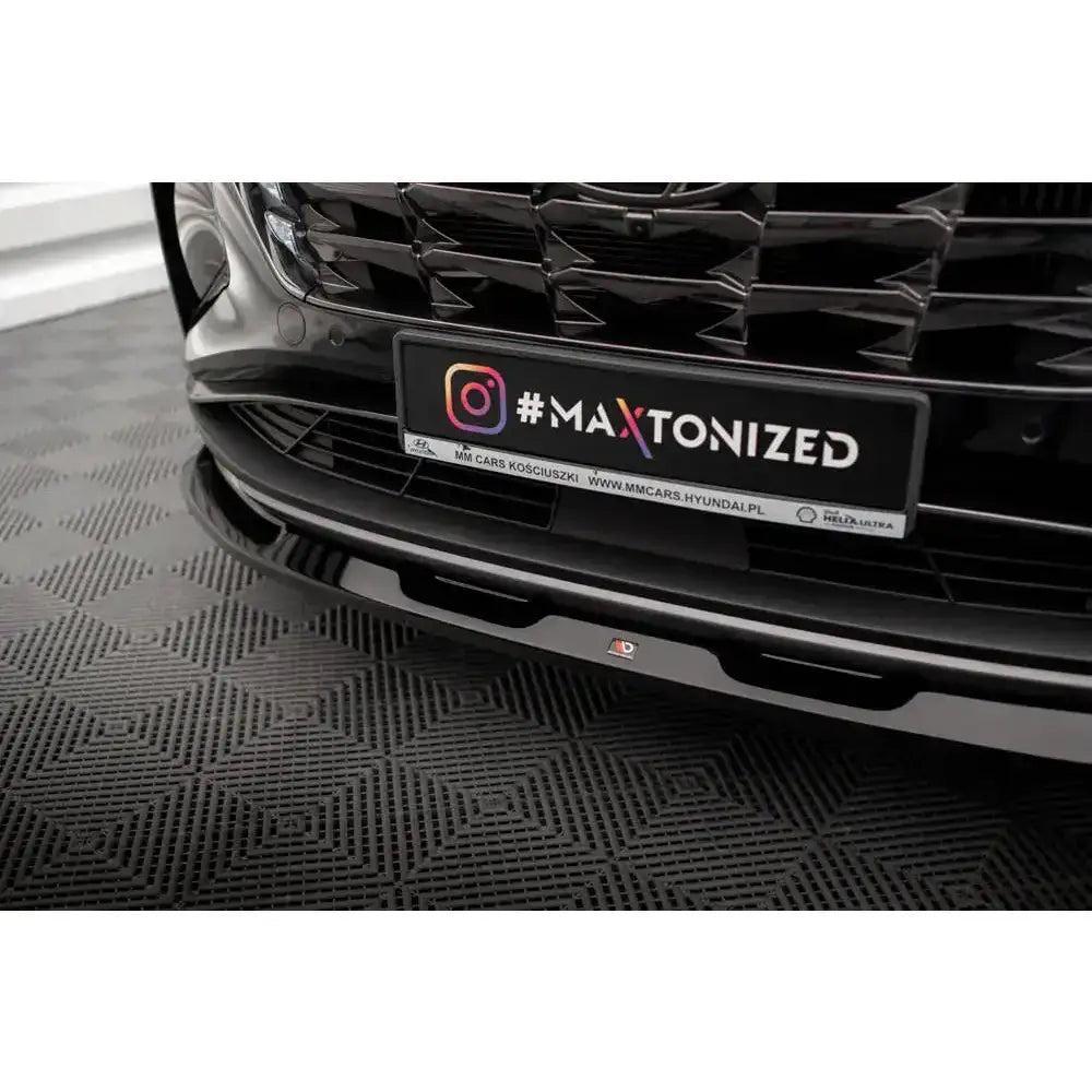 Frontsplitter Hyundai Tucson 20- Mk4 V.1 i sort blank finish montert på frontfanger sett fra lav frontvinkel.