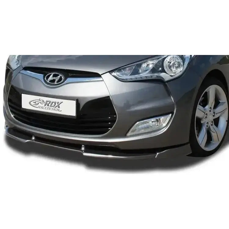 Frontleppe Hyundai Veloster 11-17 montert på grå bil, viser svart spoiler foran grill og lykter.