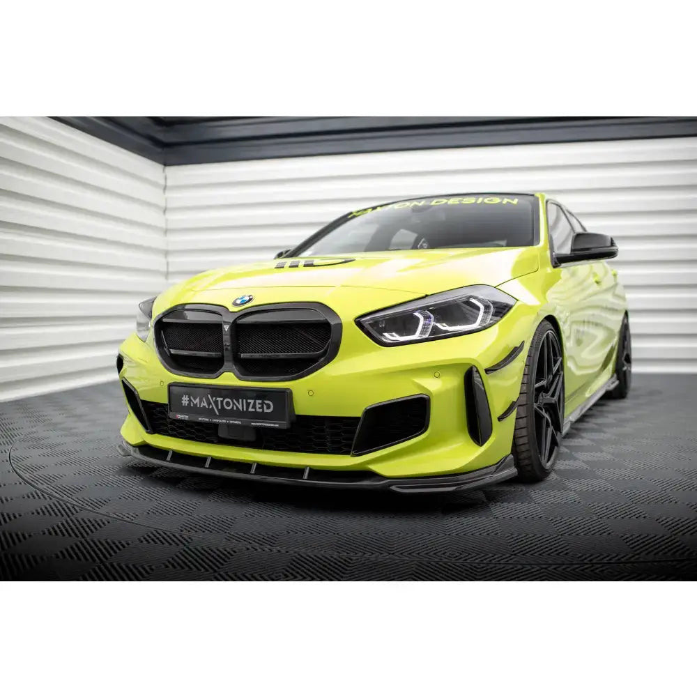 Frontspoiler på BMW 1 F40 M-Pack i karbon, vist på gul sportsbil med svarte detaljer innendørs.