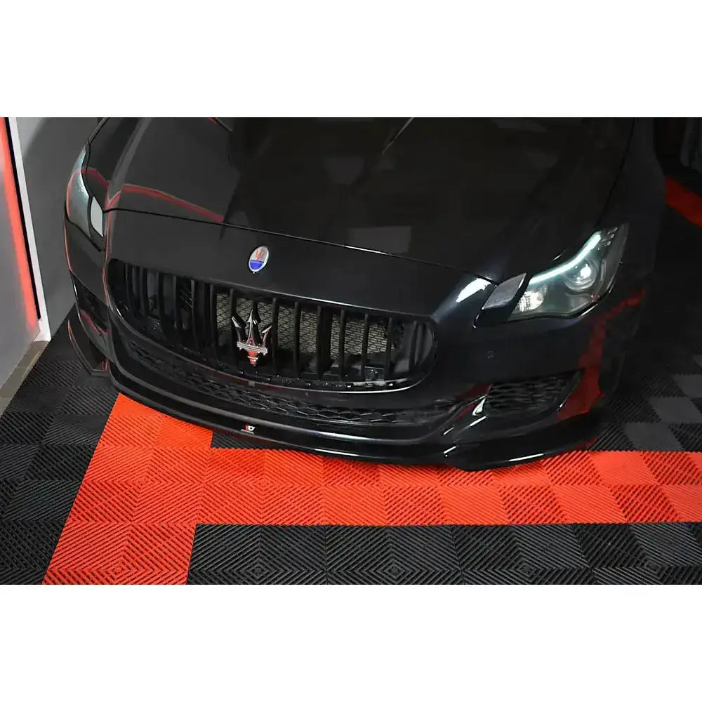 Frontspoiler på Maserati Quattroporte Mk.6 Preface sett forfra med grill og frontlys på rutete gulv.