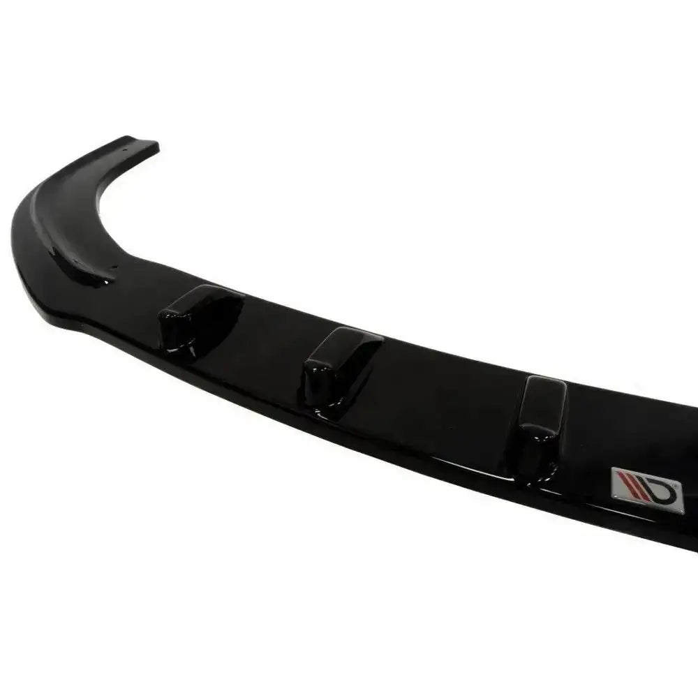 Frontsplitter til Mazda 6 Mk2 i sort blank plast med forhøyninger og logo, sett fra skrå vinkel.