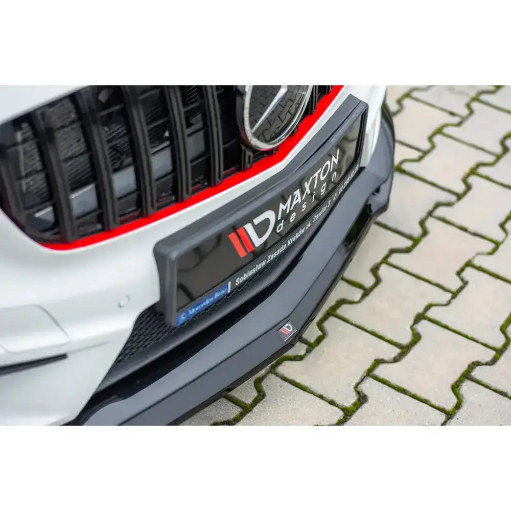 Front lip til Mercedes A45 AMG W176 med sorte og røde detaljer, sett skrått ovenfra mot brostein.
