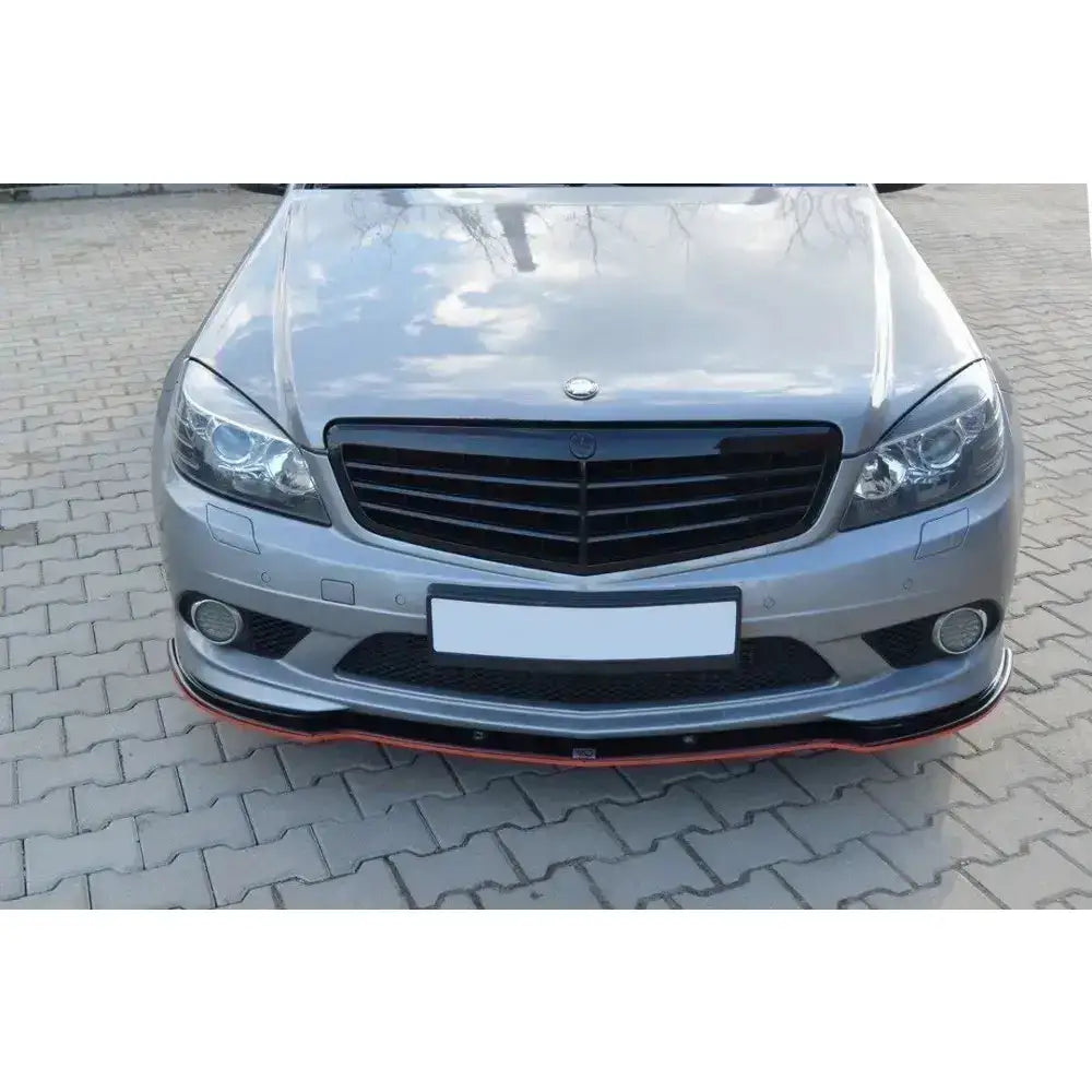 Frontspoiler på Mercedes C W204 Amg-Line med rød kant, parkert på lys brostein.