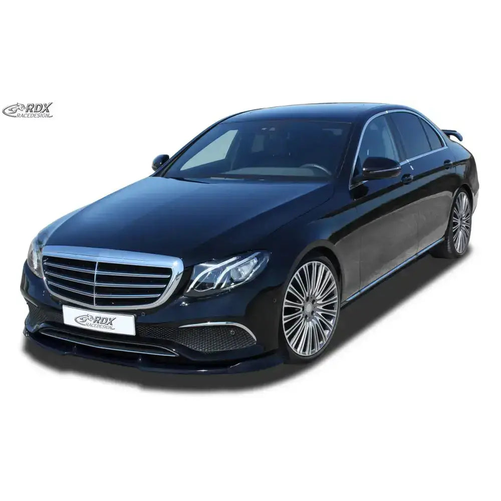Frontspoiler på sort Mercedes E-Class W213 med store felger og krom grill mot hvit bakgrunn.