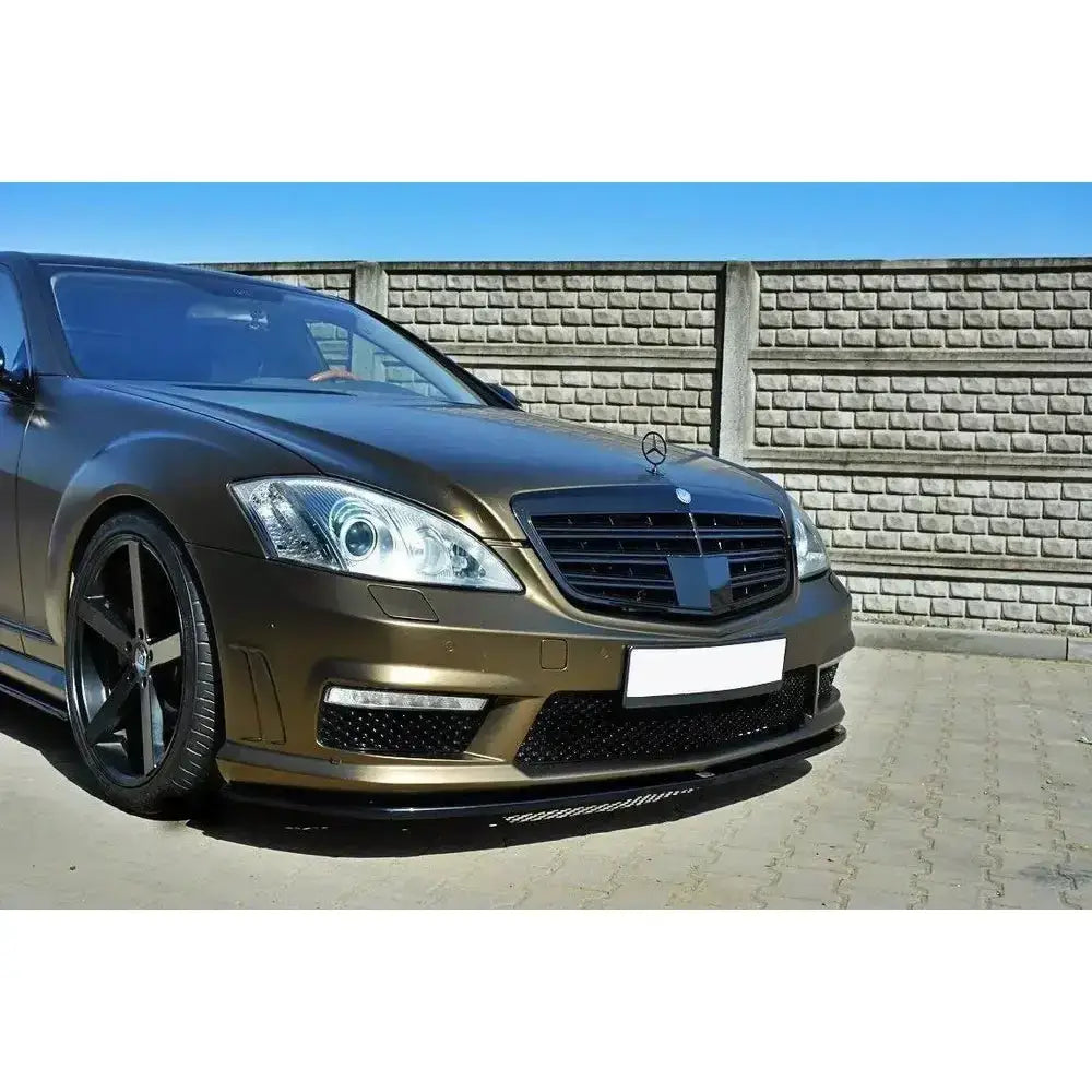 Frontspoiler på Mercedes S-Class W221 Amg i metallic brun med svarte felger foran mursteinsvegg.