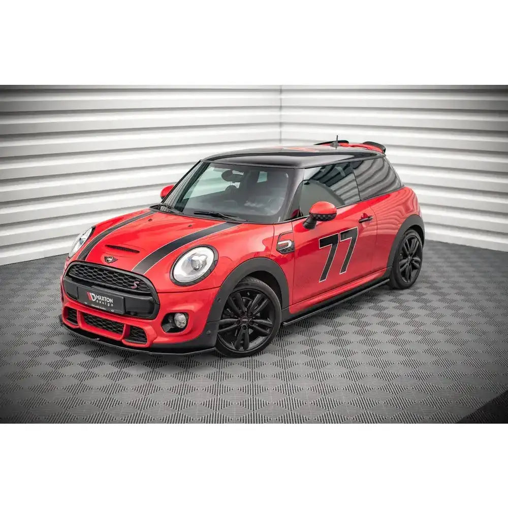 Frontspoiler på rød Mini Cooper F56 med svarte striper, tallet 77 og svarte felger sett forfra.