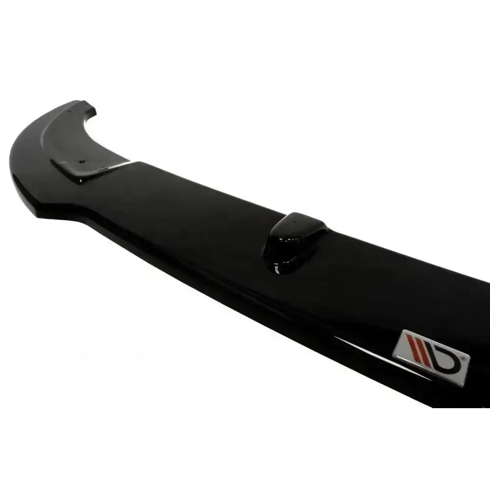 Front splitter Mini Cooper R56 Jcw i sort, blank plast med logo og monteringspunkter på hvit bakgrunn.