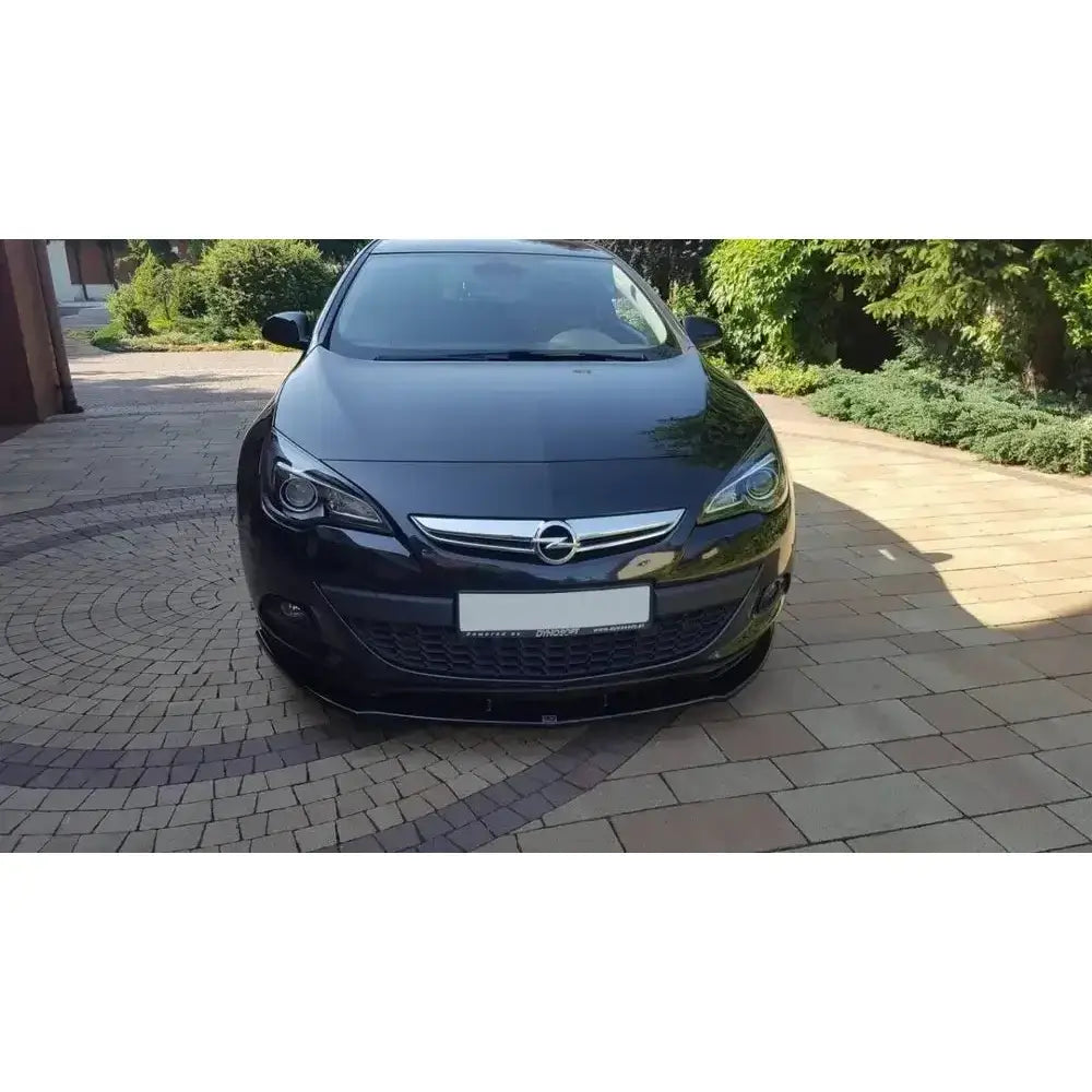 Frontspoiler til Opel Astra J Gtc, svart bil sett forfra med kromdetaljer og blank finish.