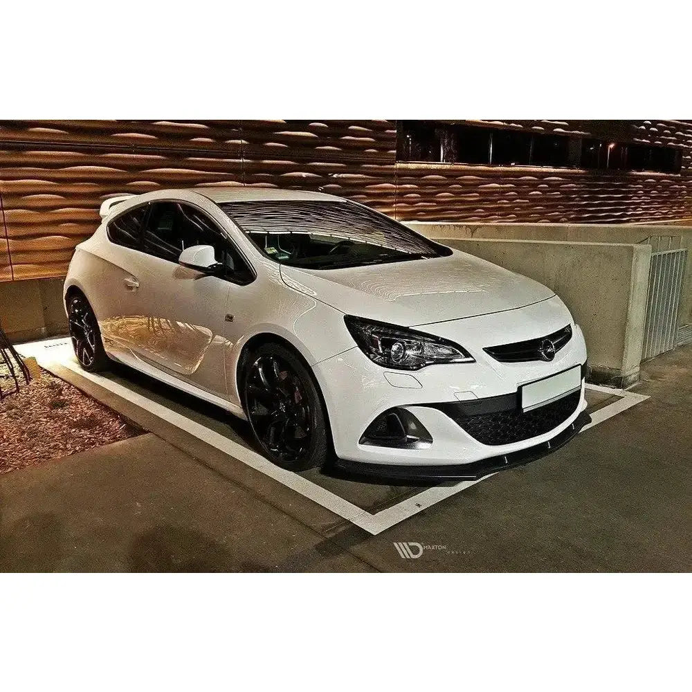Frontspoiler Opel Astra J Opc V.1 på hvit bil med svarte felger, parkert i parkeringskjeller.