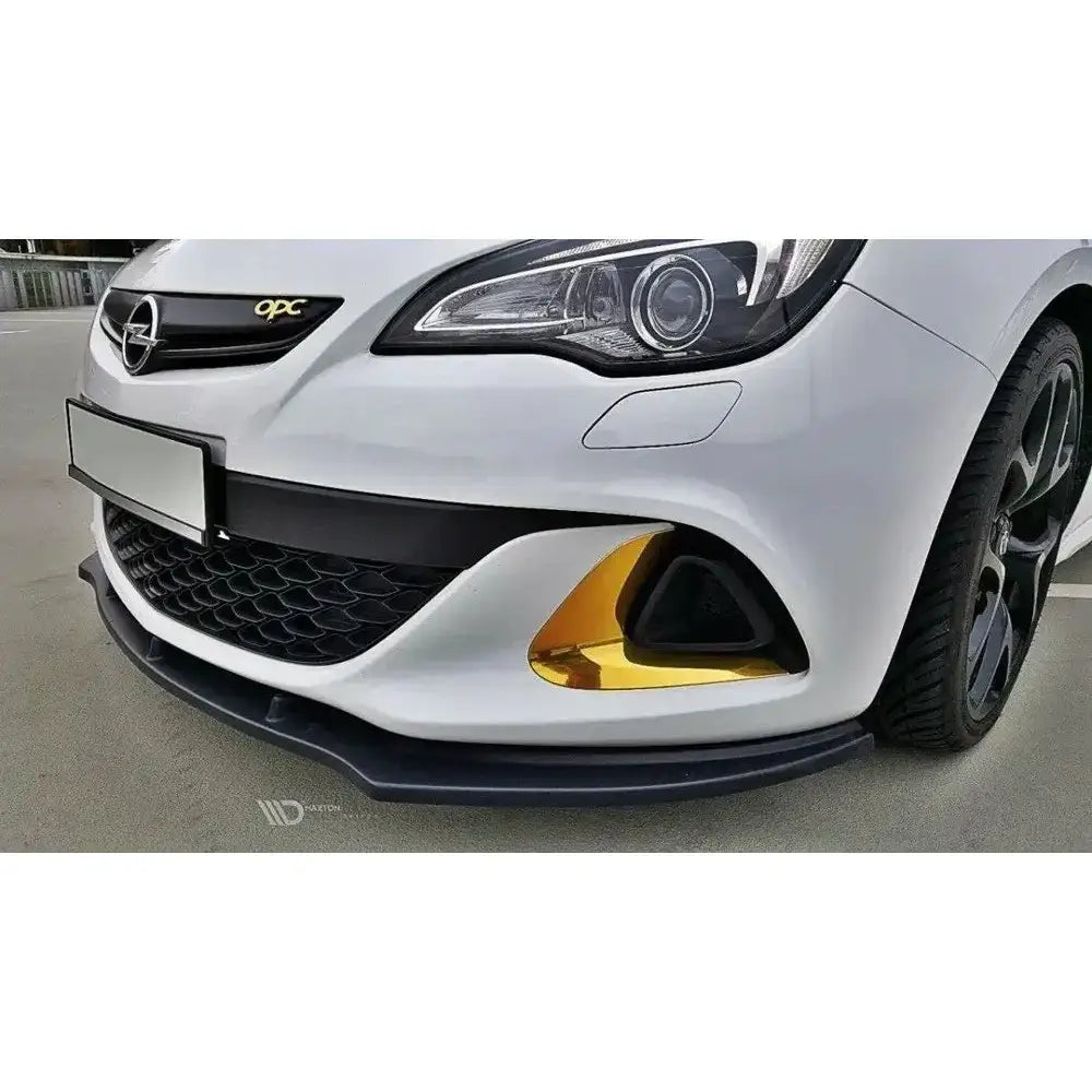 Frontsplitter til Opel Astra J OPC, sort modell med gulldetalj ved tåkelys på hvit bil.