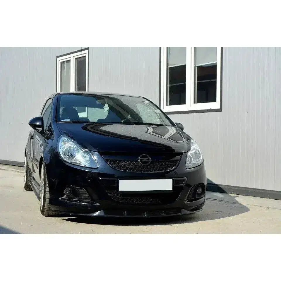 Frontsplitter på Opel Corsa D Nurburg med OPC/VXR-støtfanger, parkert foran lys grå bygning.