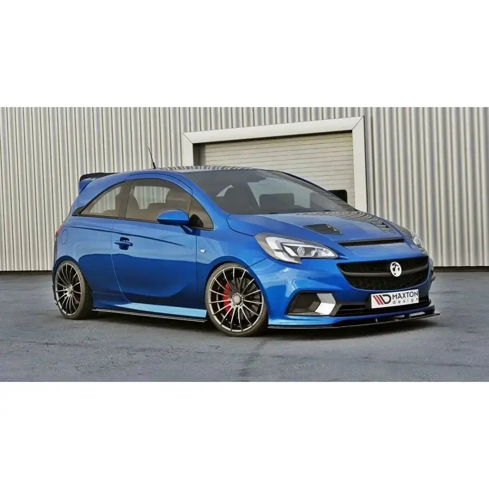 Front lip på Opel Corsa E OPC med svarte detaljer og spoilervinge, sett fra siden mot lysegrå vegg.