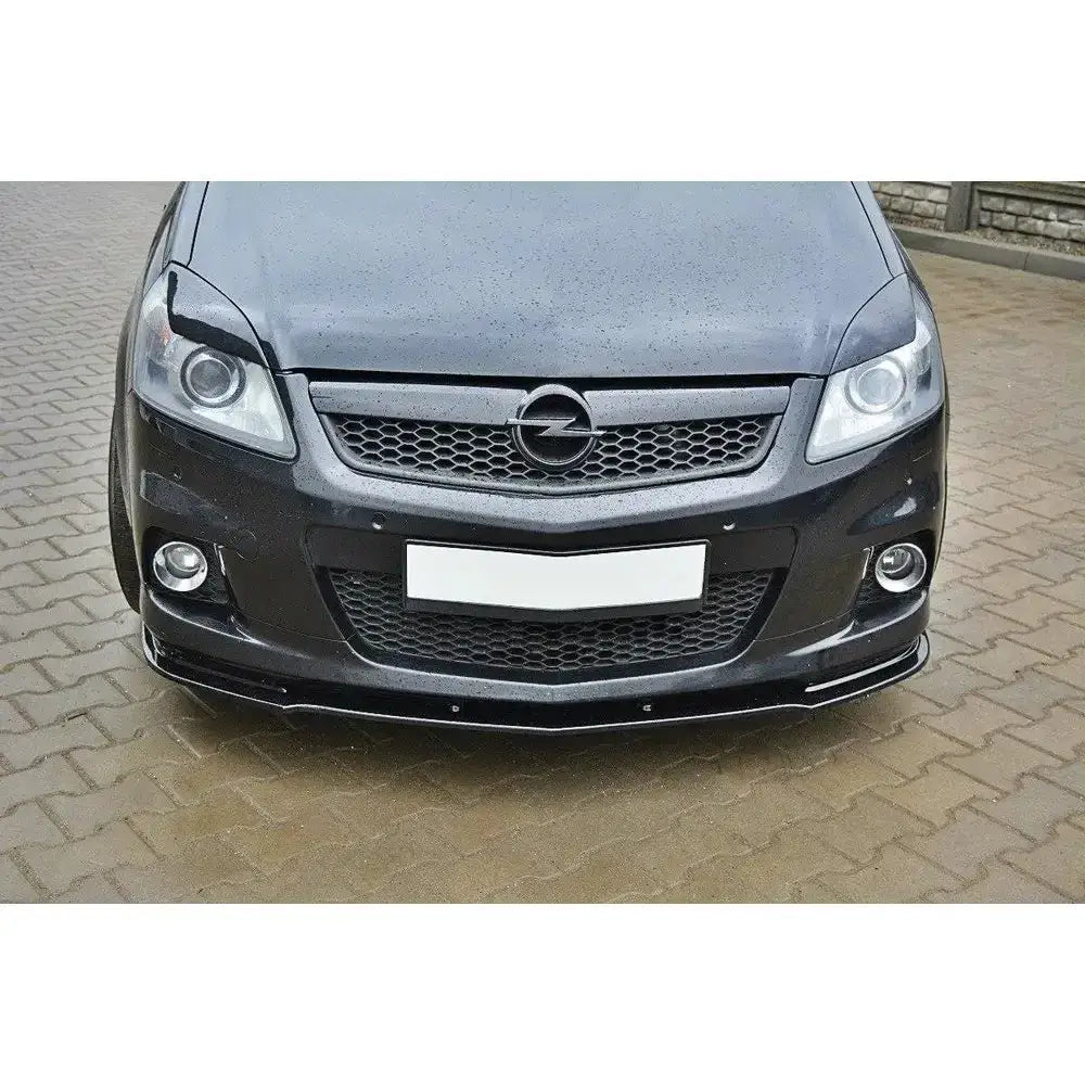 Front lip Opel Zafira B OPC med blank sort frontspoiler og heksagonalt grillmønster på brostein.