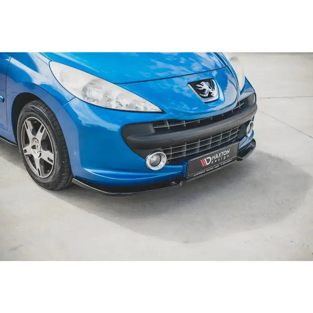 Frontsplitter på Peugeot 207 Sport, blå bil med svart frontsplitter, tåkelys og felger synlige.