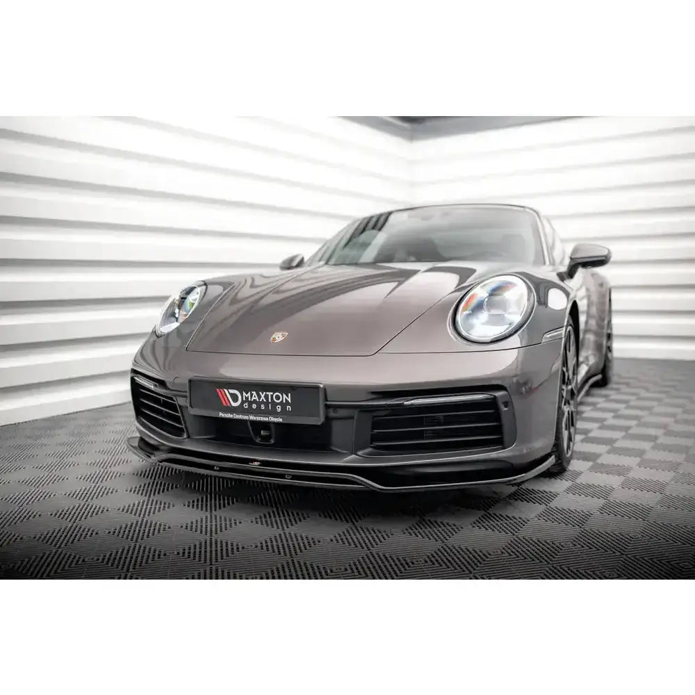 Frontspoiler på Porsche 911 Carrera 4S 992, sett forfra med grå lakk og tydelig logo på panseret.