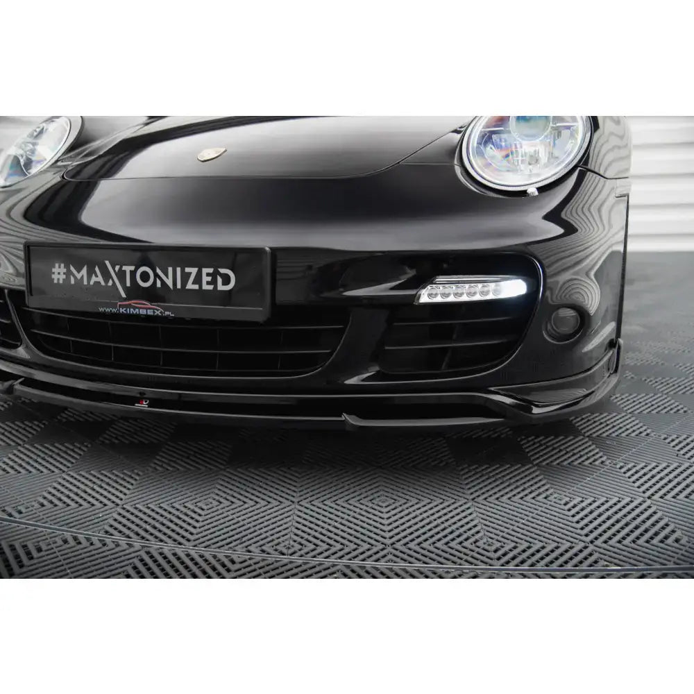 Frontleppe Porsche 911 Turbo 997 vist fra lav vinkel med LED-lys og markert spoiler på sort bil.