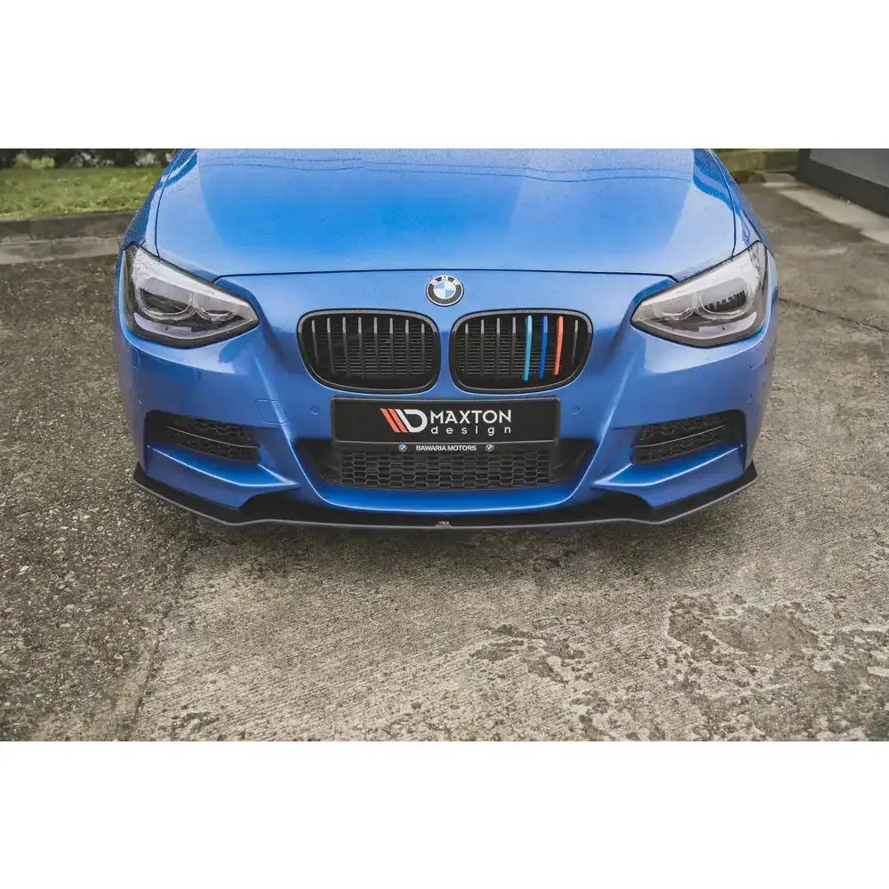 Frontsplitter på blå BMW M135i F20 med svart grill, fargedetaljer og Maxton Design-logo foran.