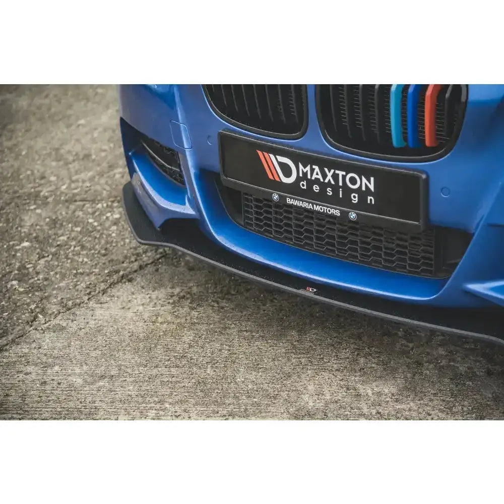 Front splitter på BMW M135i F20, sort spoiler fra Maxton Design sett forfra på blå bil.