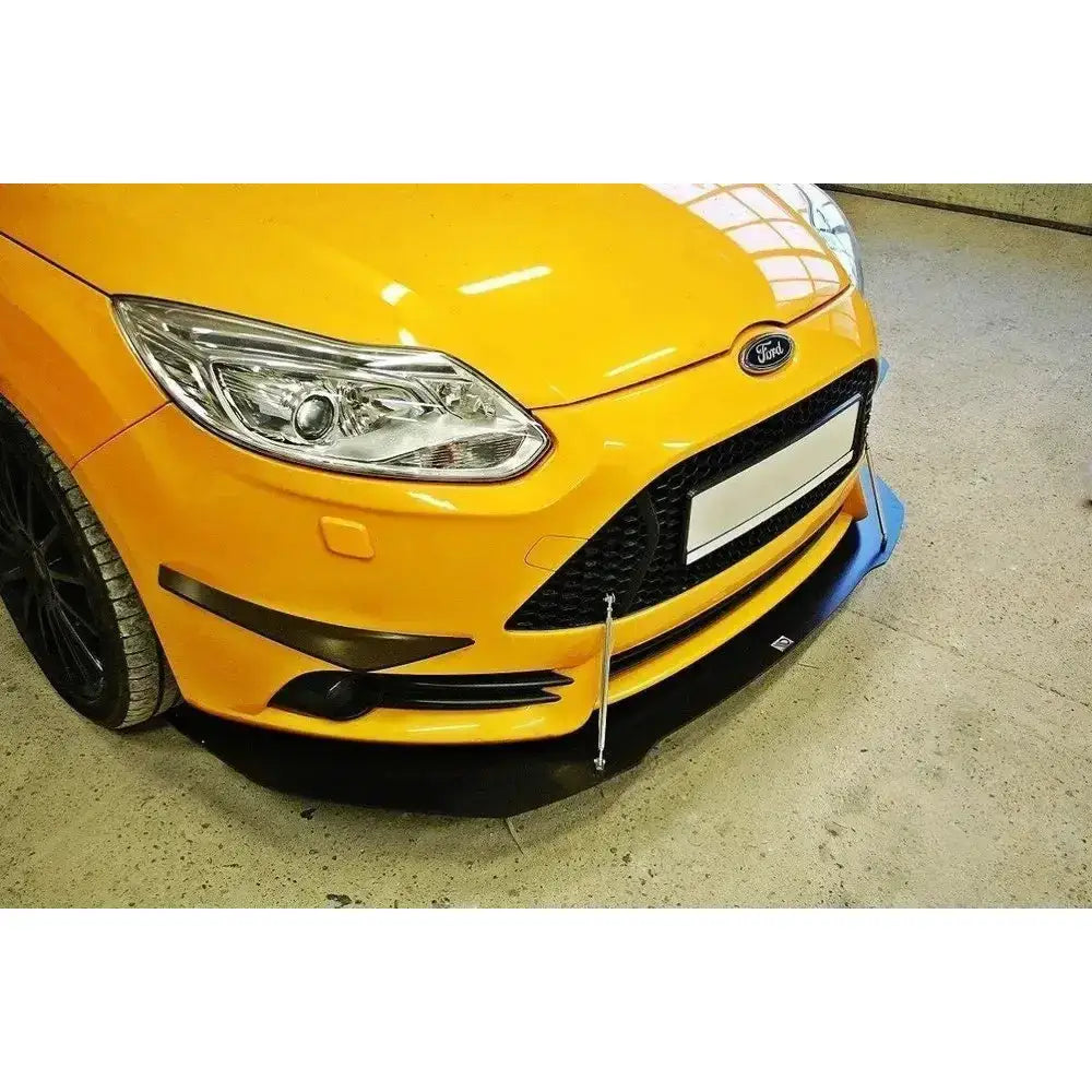 Frontspoiler på gul Ford Focus ST Mk3 med sorte støttearmer og detaljerte lykter og grill.