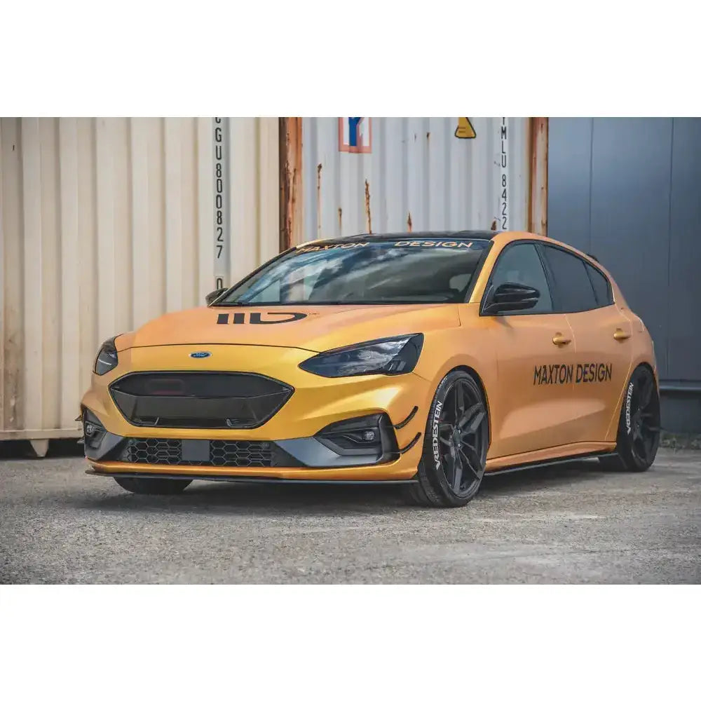Frontsplitter på gul-oransje Ford Focus ST med svarte detaljer og Maxton Design-logoer, sett forfra og fra siden.