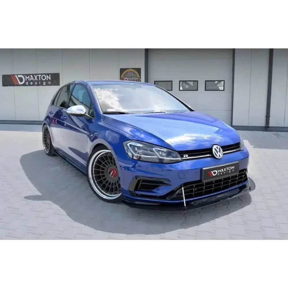 Front lip på blå VW Golf VII R facelift med sorte detaljer og store felger, sett fra venstre forhjørne.