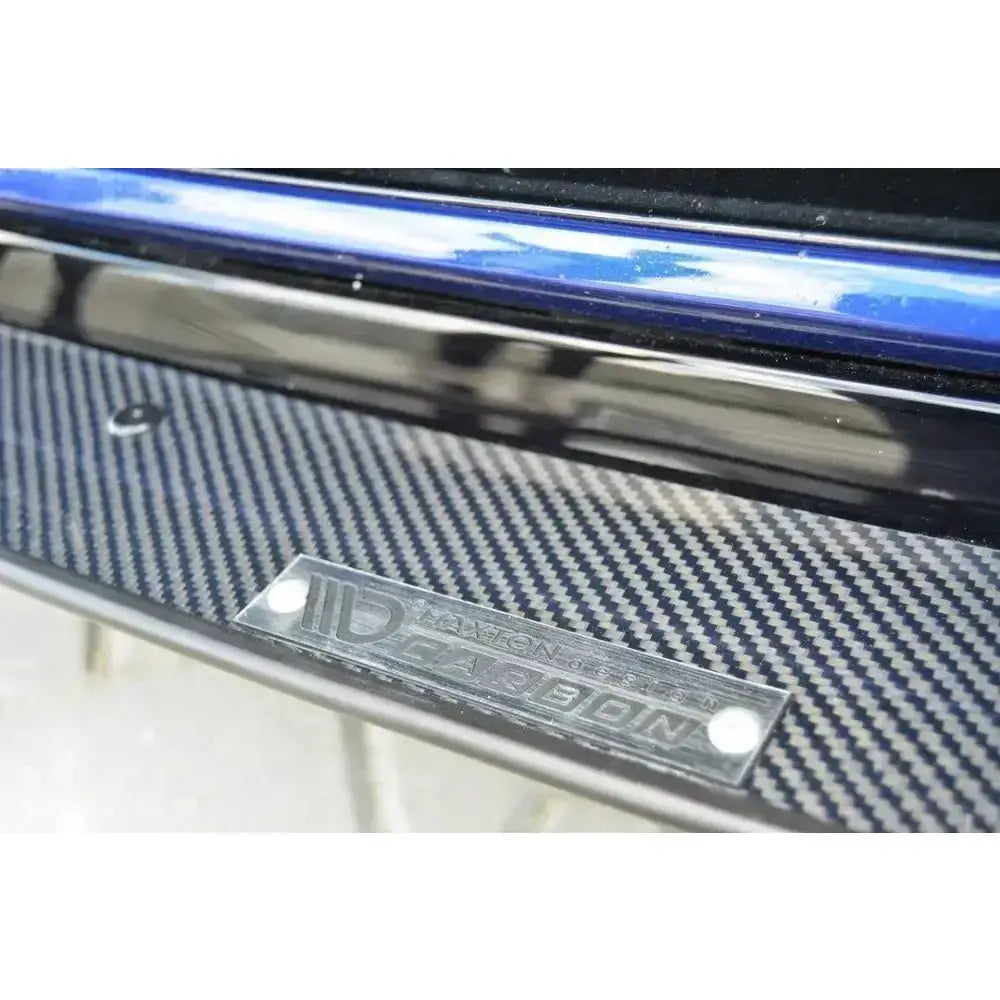 Frontleppe Racing Hybrid Vw Golf VII R med karbonfiberoverflate og synlig logo-plate ved blå bilkant.