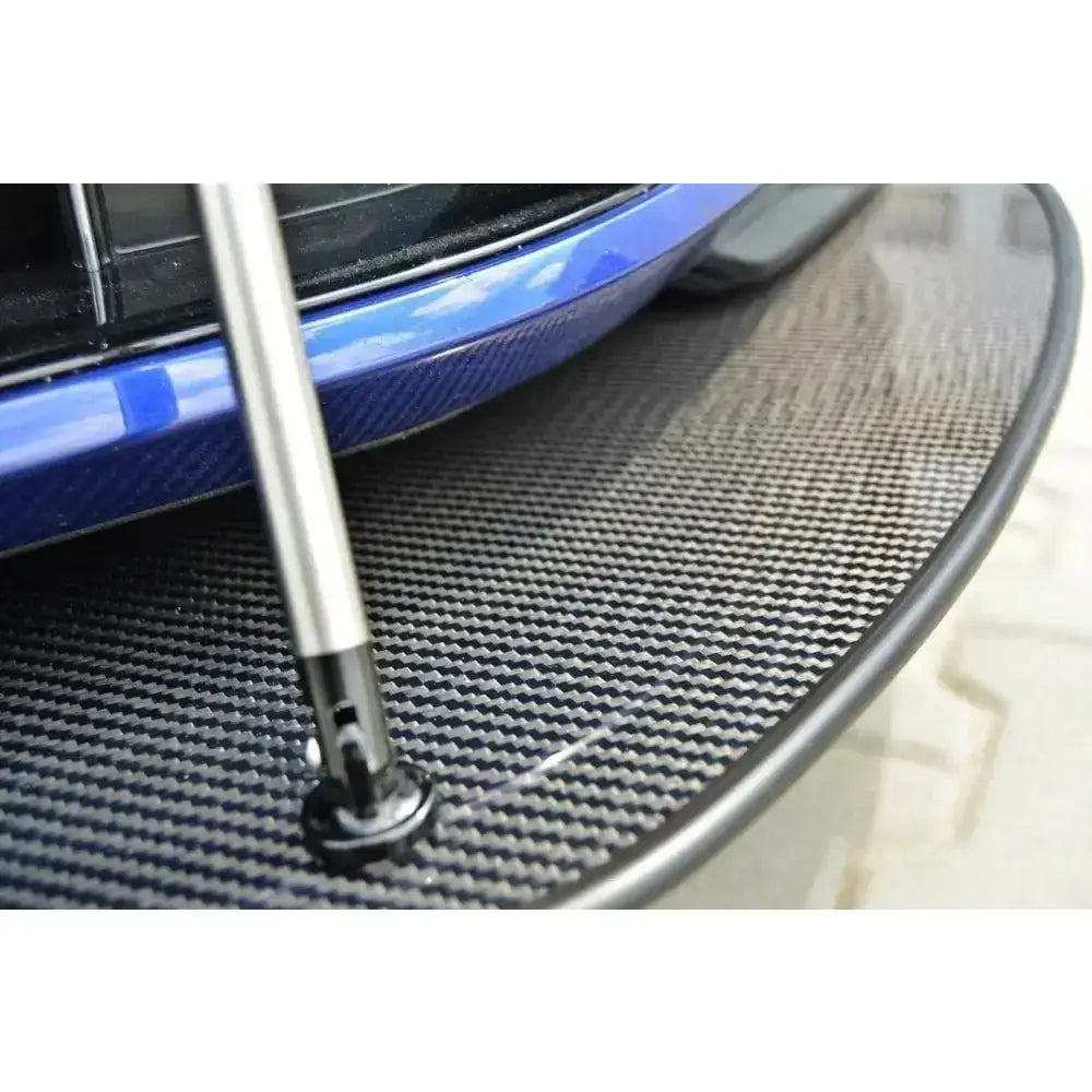 Frontspoiler Racing Hybrid Vw Golf VII R i karbonfiber med blank finish og metallstag, nærbilde på blå støtfanger.