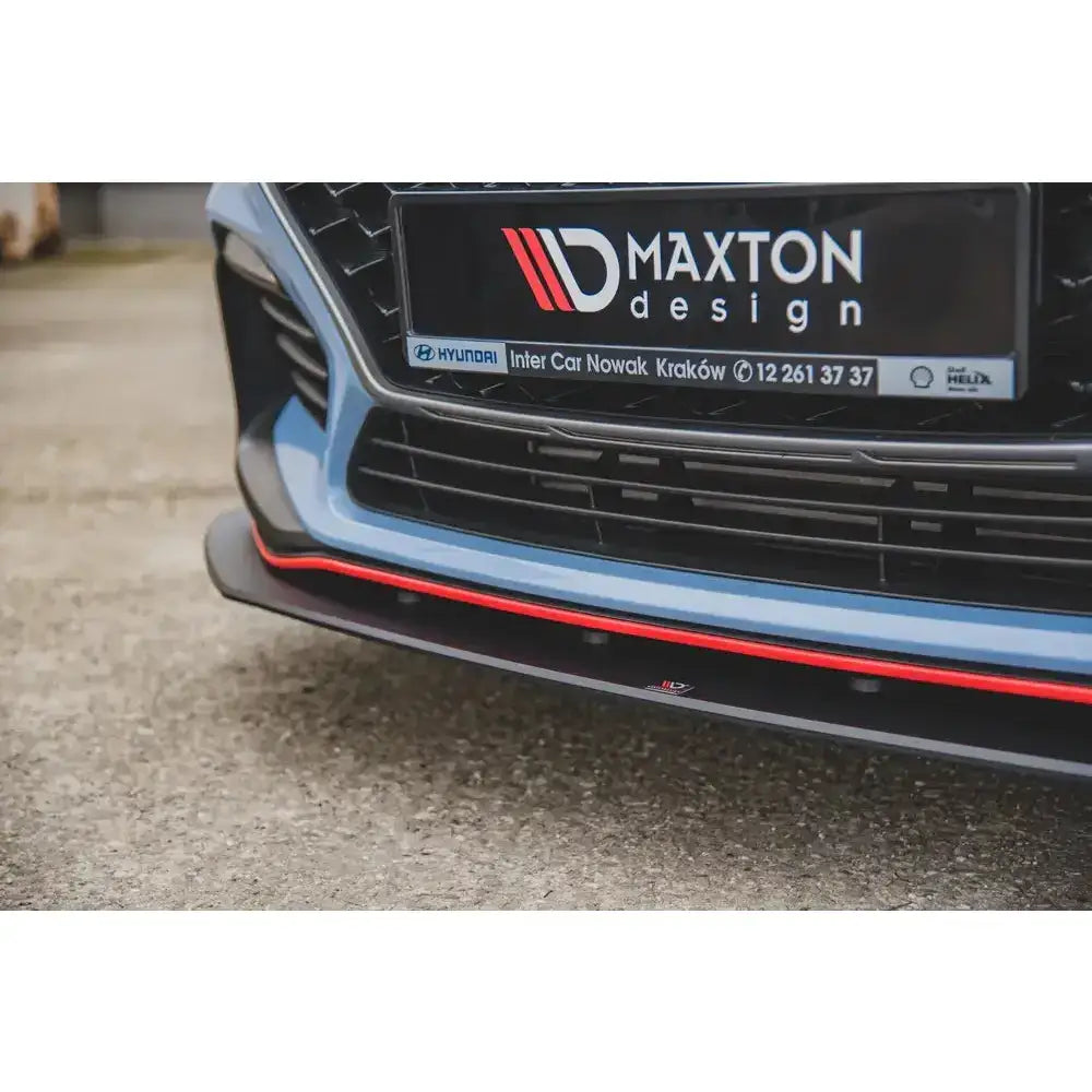 Front splitter til Hyundai I30 N Mk3 montert med rød stripe, sett skrått forfra mot asfalt.