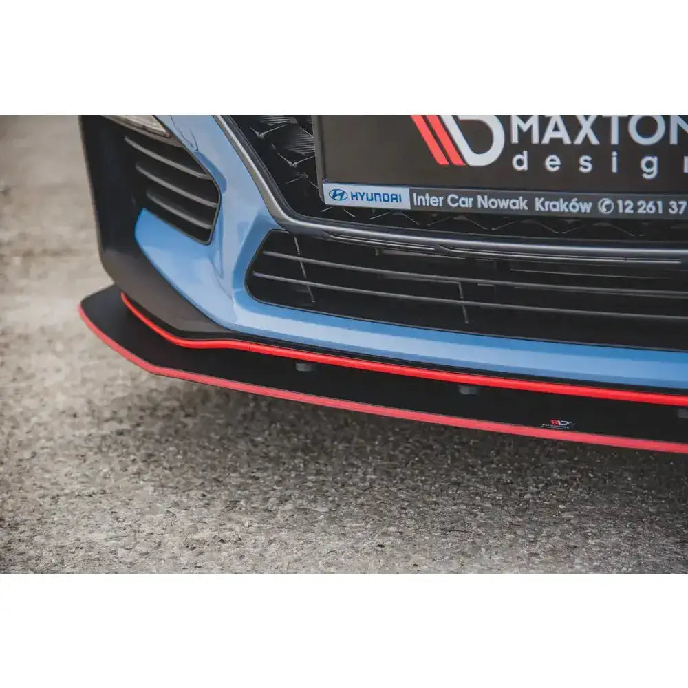 Frontsplitter til Hyundai I30 N Mk3, sort med rød kant, montert på lyseblå bil, sett forfra.