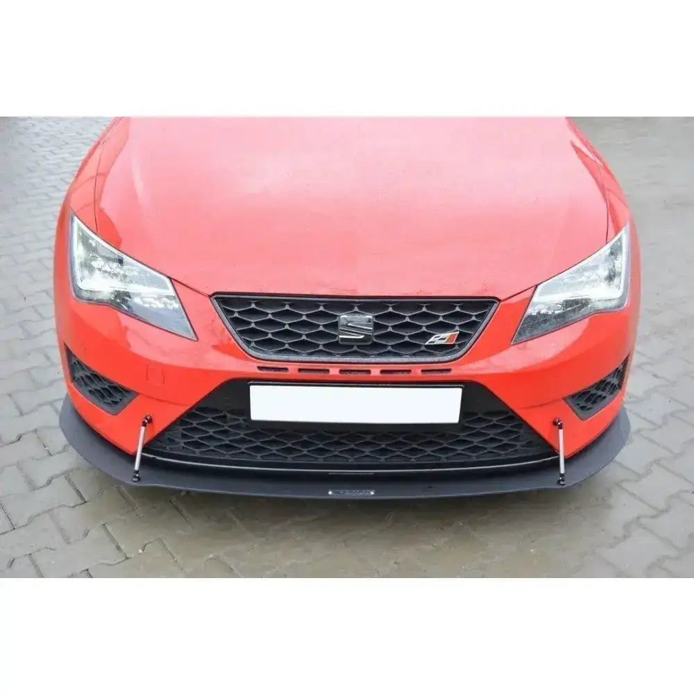 Frontspoiler på rød Seat Leon III Cupra med sorte detaljer og metallstøtter, parkert på brostein.