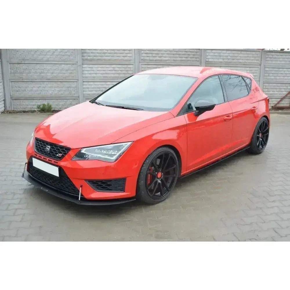 Front splitter på rød Seat Leon III Cupra med sorte felger og lav spoiler, fotografert utendørs.