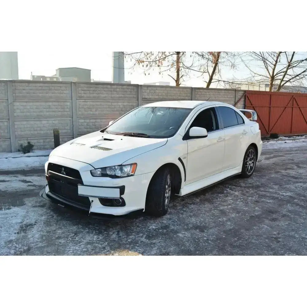 Front splitter på Mitsubishi Lancer Evo X med sorte detaljer, store felger og bakspoiler på vinterasfalt.